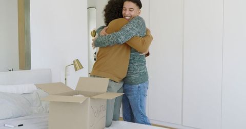 Friends hugging near donation box highlighting charity and generosity