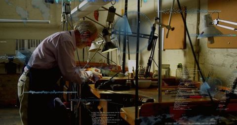 Senior Artisan Crafting Precision Metalwork at Workbench with Loupe and Pliers