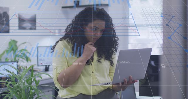 Focused Businesswoman Analyzing Data on Laptop with Digital Graph Overlays - Download Free Stock Images Pikwizard.com