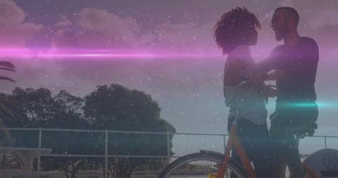 Romantic Couple with Bicycle Under Majestic Sky