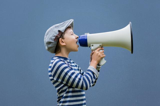 Digital composite of Side view of boy shouting on megaphone against blue background