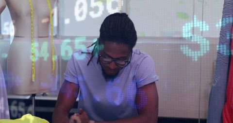 Fashion designer studying sketches in creative studio with digital data overlay and mannequin
