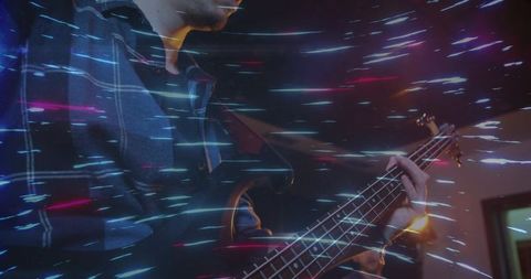 Electric bassist performing with light streak effects