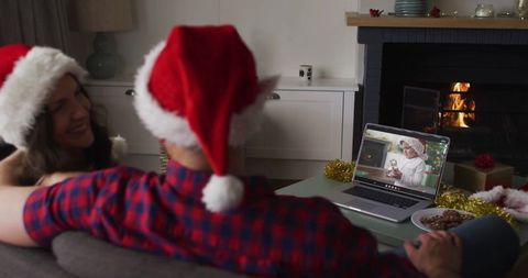 Couple in Santa Hats Video Calling Family at Home During Festive Season
