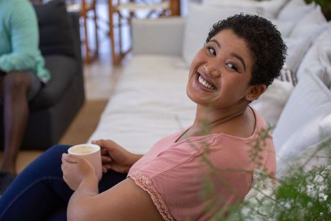 Joyful Woman with Coffee Mug Enjoying Relaxing Moment at Home