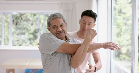 Senior Man Receiving Physical Therapy Assistance at Home