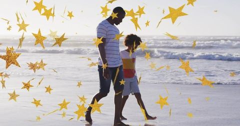 Father and son walking along sunlit beach with gold star overlay and reflective shoreline