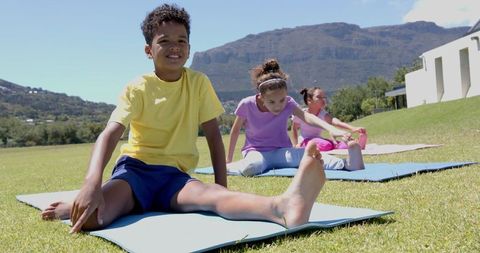 Children Practicing Yoga Outdoors on Sunny Day with Mountain View