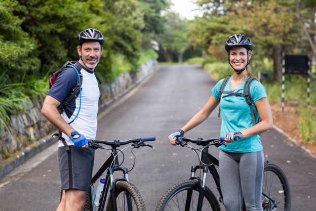 Happy Athletic Couple with Mountain Bikes on Open Road - Download Free Stock Photos Pikwizard.com