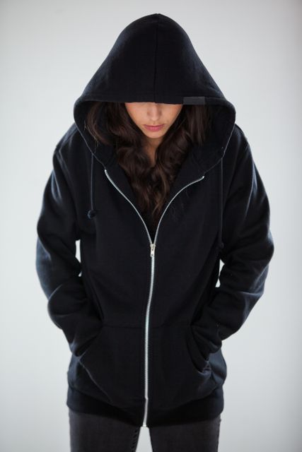 Spy in a hoodie standing against white background
