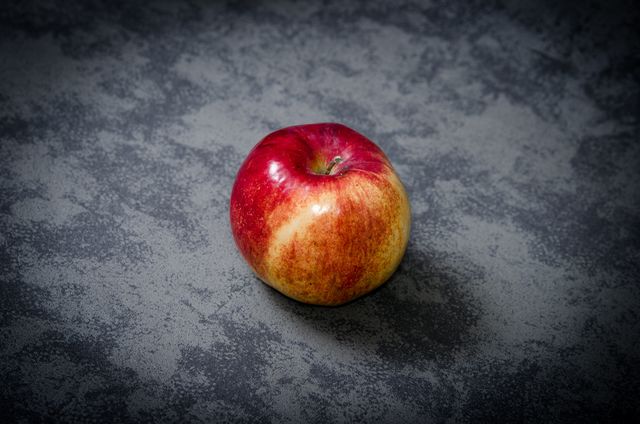 Close-Up of Fresh Red and Yellow Apple on Gray Surface - Download Free Stock Photos Pikwizard.com