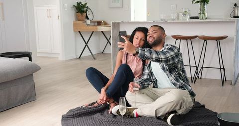 Couple Celebrating at Home with Champagne and Selfies