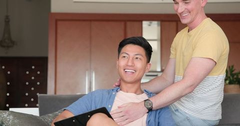 Diverse male couple enjoying leisure time together at home