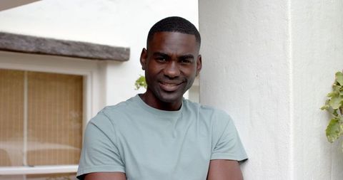 Confident Man Leaning on Porch in Relaxed Modern Setting
