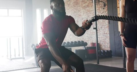 Gymgoer Engaging in Battle Ropes Workout for Enhanced Stamina