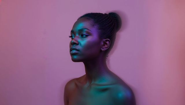 Cinematic duotone portrait black woman with braided bun bare shoulders pink gel light