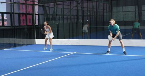 Coed Players on Padel Court Show Enthusiastic Competitiveness