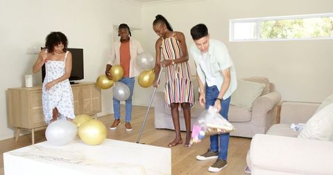 Group of Friends Decorating Living Room for Celebration
