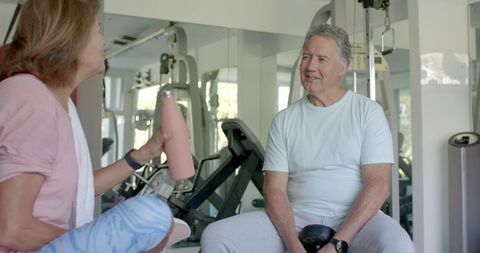 Senior Couple Enjoying Chat During Workout Session in Gym
