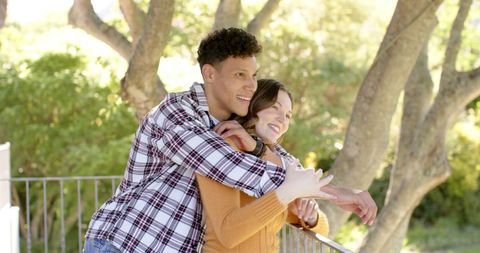 Couple Embracing on Balcony with Natural View