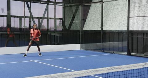 Young Man Playing Padel Tennis on Modern Blue Court
