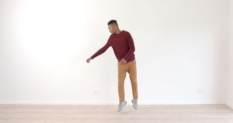 African american man dancing energetically on wooden floor