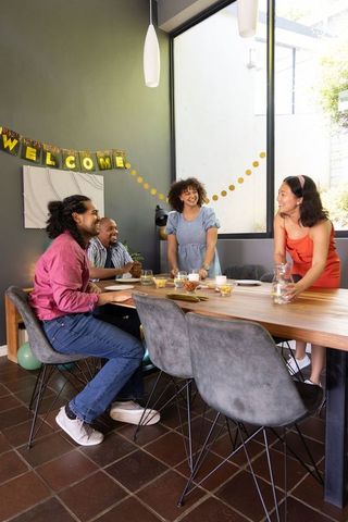 Diverse Group Enjoying Celebration Gathering at Home with Welcome Banner