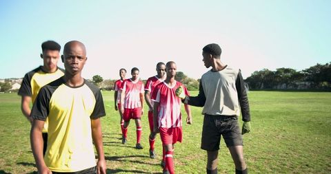 Diverse Soccer Team Walking Together on Grassy Field