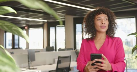 African American Businesswoman Gazing with Smartphone in Modern Office