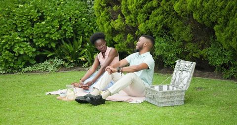 Romantic couple enjoying a picnic in lush garden setting