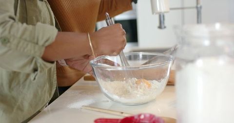 African American Couple Whisking Batter Together in Bright Home Kitchen, Closeup