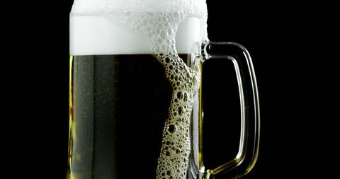 Foamy Beer Mug Overflow with Dark Background