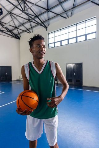 Basketball Player in Gymnasium: Focus and Preparedness