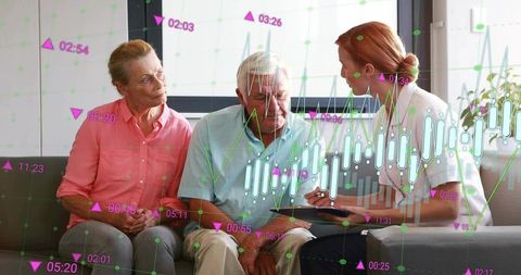 Clinician explaining health data to elderly couple using tablet with charts overlay