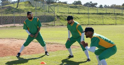 Multiethnic Baseball Teammates Warming Up on Grass Field During Defensive Drill