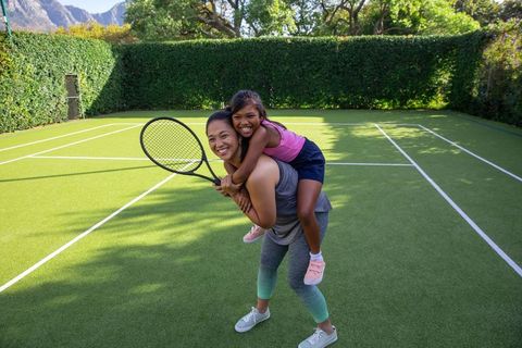 Mother and Daughter Enjoying Tennis Together on Bright Day