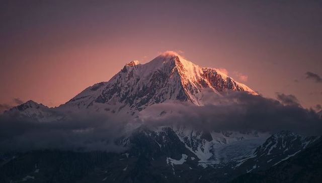 Majestic Snow-Capped Peak at Dawn with Pink-Orange Glow