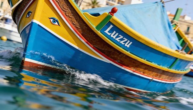 Colorful maltese luzzu boat bow with painted eye moving through calm harbor water