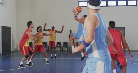 Basketball players competing with intense action on indoor court