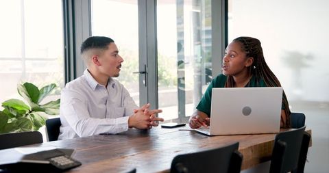 Diverse Colleagues Discussing Project at Office Table
