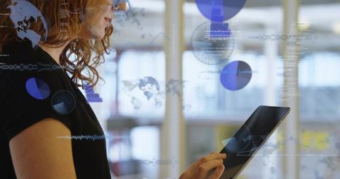 Woman using tablet interacting with ar data overlays showing analytics, world map, charts