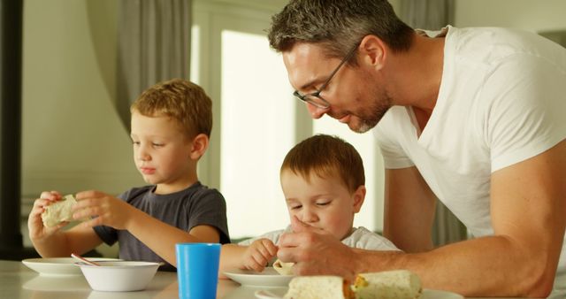 Father Enjoying Meal with Two Young Sons at Dining Table - Download Free Stock Images Pikwizard.com