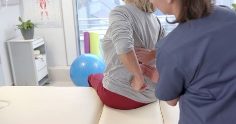 Senior Woman Receiving Back Massage in Physiotherapy Session