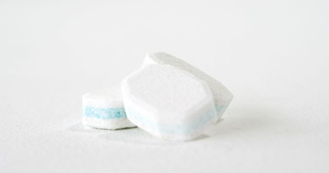 Dishwasher tablets are displayed against a clean white background, with copy space. These tablets are essential for modern cleaning routines, providing convenience and efficiency in dishwashing.