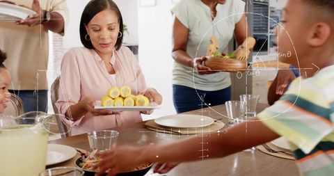Multigenerational family serving summer dinner around table with corn salad and lemonade