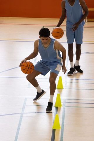 Teammates Practicing Basketball Dribbling with Cones