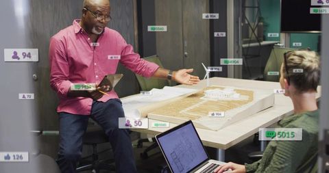 Architect presenting scale model and digital plans in collaborative office design meeting
