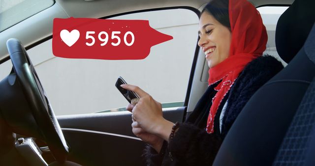 Close up of a female Muslim texting while smiling inside a car. Beside her is a digital image of a message bubble with a heart icon increasing in count.
