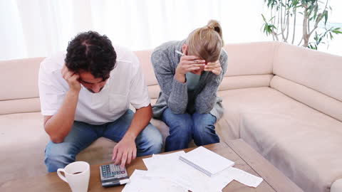 Stressed Couple Calculating Expenses at Home