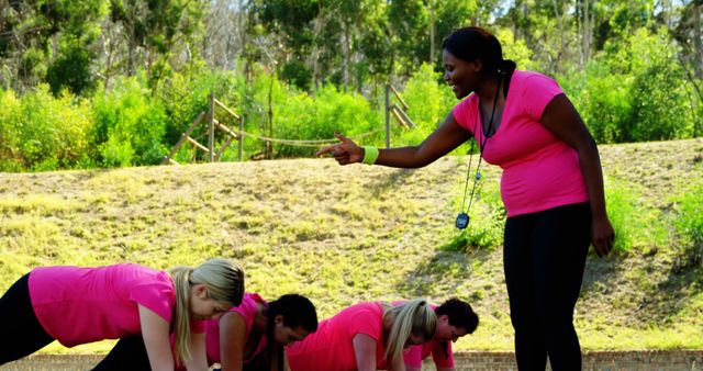 This vibrant scene captures a fitness instructor guiding participants in an outdoor setting, highlighting collaboration and healthy living. Ideal for promoting active lifestyle campaigns, gym advertisements, or instructional fitness content. The image's dynamic nature and clear composition make it effective for health promotions and motivational materials related to sports and training.